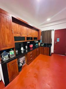 a kitchen with wooden cabinets and black counter tops at D Villa Nuwara Eliya in Sita Eliya +5 photos