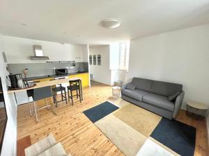 a living room with a couch and a kitchen at Le Mandragot - Séjour en Aspe in Bedous