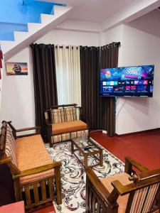 a living room with chairs and a flat screen tv at D Villa Nuwara Eliya in Sita Eliya