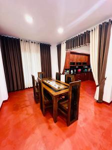 a dining room with a wooden table and chairs at D Villa Nuwara Eliya in Sita Eliya