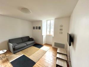 a living room with a couch and a television at Le Mandragot - Séjour en Aspe in Bedous