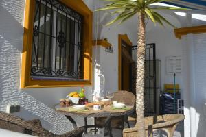 a table with food and a palm tree on a patio at SUPERBE MAISON VISTABELLA Golf in Orihuela Costa