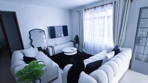 a living room with a white couch and a tv at EBM Homes in Nairobi