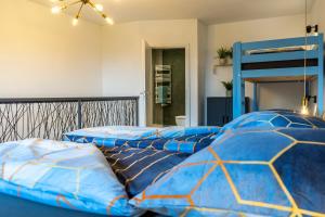 two beds with blue comforters in a bedroom at Modern Western - Apartment Blue in Eging