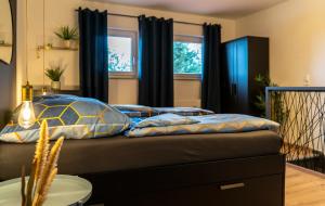 a bed with pillows on it in a room at Modern Western - Apartment Blue in Eging