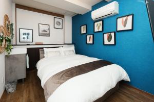 a bedroom with a blue wall with a bed at Prosper 47th bldg in Nagoya +32 photos