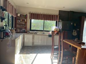 a kitchen with white cabinets and a large window at Baan Mada Lanta villa in Ko Lanta