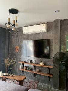 a living room with a flat screen tv on a wall at Baan Mada Lanta villa in Ko Lanta