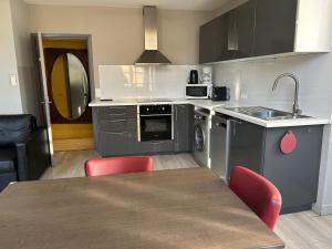 a kitchen with a sink and a table with red chairs at Les Appartements Carré d'or - Nice Centre in Nice