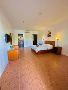 a large bedroom with a bed and a television at Landcons Hotel & Resort in Pantai Cenang