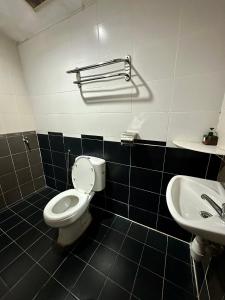 a bathroom with a toilet and a sink at Landcons Hotel & Resort in Pantai Cenang