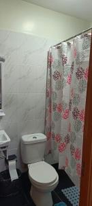 a bathroom with a toilet and a shower curtain at BlueByMis Studio Apartment in Muchatha +34 photos