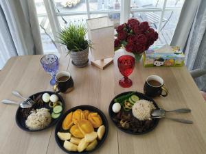 a table with three plates of food and flowers at Sla guest house in Boracay