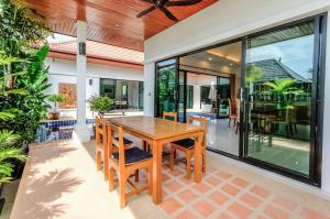 a dining room with a wooden table and chairs at Chambertin Villa by G Estate in Rawai Beach