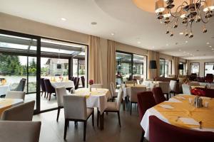a restaurant with tables and chairs and a chandelier at Hotel Airport Suites Suitable for Hourly Bookings in Lucknow