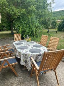 a table with four chairs around it with a vase on it at Maison Tulipe in Puivert +5 photos