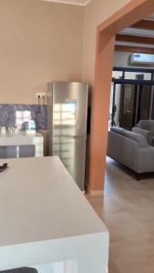 a kitchen with a stainless steel refrigerator and a couch at Luxury Private Villa with Pool in The Gambia in Sambuya +36 photos