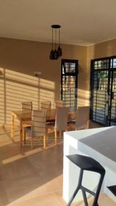 a dining room with a wooden table and chairs at Luxury Private Villa with Pool in The Gambia in Sambuya