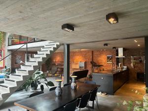 a living room with a staircase and a table at Stylish Loft with Industrial Charm in Kortenberg