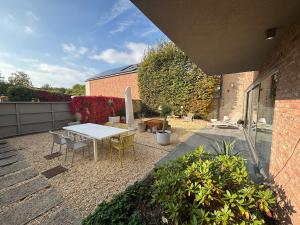 a patio with a table and chairs in a yard at Stylish Loft with Industrial Charm in Kortenberg
