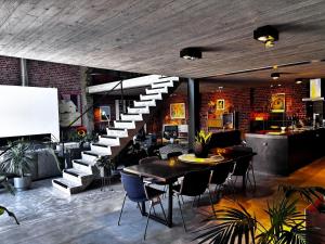 a room with a staircase and a table and chairs at Stylish Loft with Industrial Charm in Kortenberg