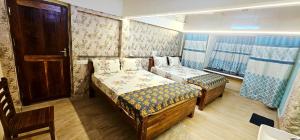 a small room with two beds and a window at Lavanya Regency Floor Kanchipuram in Kanchipuram