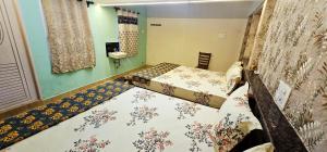 a bedroom with two beds and a wall at Lavanya Regency Floor Kanchipuram in Kanchipuram