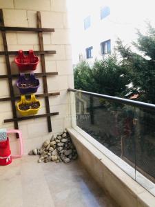 a balcony with red and yellow chairs on a wall at Chic 2-Bedroom - Fully Furnished in Amman