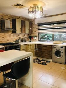 a kitchen with a sink and a dishwasher in it at Chic 2-Bedroom - Fully Furnished in Amman