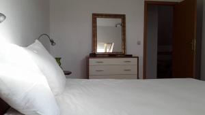 a bedroom with a white bed and a mirror at At the Villa in Tournai