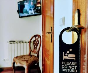 a sign that says please do not disturb next to a chair at Xixi Cama Bed & Breakfast in Bombardeira