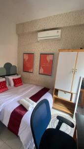 a bedroom with a large bed and a chair at DYAZA LV Grogol Guest House in Jakarta