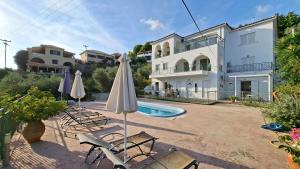 a villa with a swimming pool in front of a house at Ninareti Studios in Agia Paraskevi