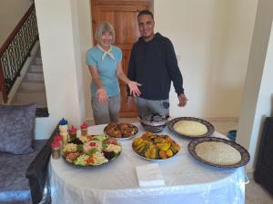 a man and a woman standing next to a table of food at Kasbah Anisi in Irhels