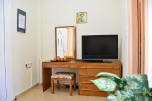 un televisor sentado en la parte superior de un tocador de madera en Georgias Apartments, en Charaki