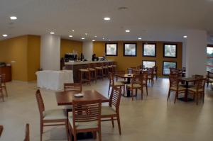 un comedor con mesas y sillas y un bar en Hotel Balneario de Graena en Graena
