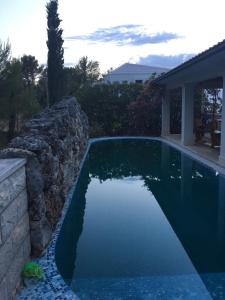 a swimming pool next to a stone retaining wall at Apartments on Gorana Pavlova 24 in Sutivan