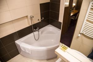 a bath tub in a bathroom with a shower at Hotel Maksymilian in Krakow