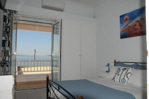 a bedroom with a bed and a view of the ocean at Sunset by the sea 1 in Loutraki
