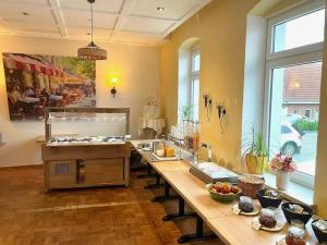 a large kitchen with a long table with food at Hotel Kieler Förde & Free Parking in Kiel
