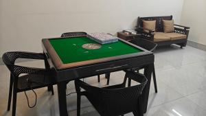 a ping pong table with four chairs and a table with a poker at HUAMENG Hotel in Dhaka