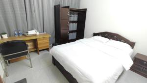 a bedroom with a bed and a desk and a phone at HUAMENG Hotel in Dhaka