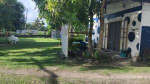 a house with a tree next to a yard at Huahine's Place in HUH +2 photos