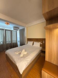 a bedroom with a large bed with white sheets and pillows at FIRONA FLY HOTEL in Sapa