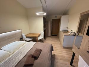 a bedroom with a bed and a table and a kitchen at Apartamenty przy Obrze in Skwierzyna