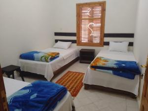 a room with two beds and a window at Kasbah Anisi in Irhels