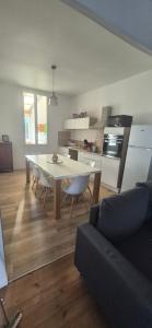 a living room with a table and a kitchen at La demeure du 159 in Cognac +23 photos