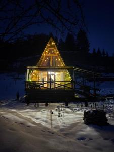 a house with lights on it in the snow at Sadyba Lileya in Verkhovyna