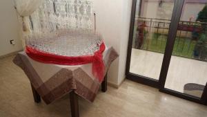 un tavolo di vetro con un panno rosso sopra accanto a una finestra di Marigab a Turceni