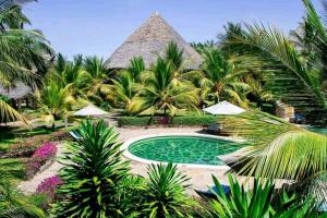 a resort with a swimming pool and palm trees at Tembo Beach Cottage , Ocean Beach Drive in Malindi